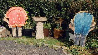 Life sized painting of "gardeners" bending over tending weeds