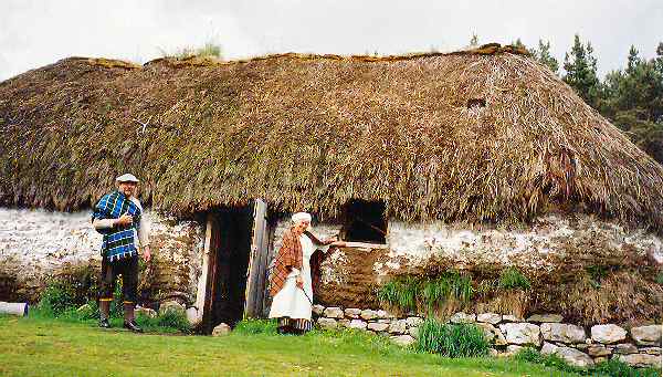 Guides stand beside reconstructed cottage