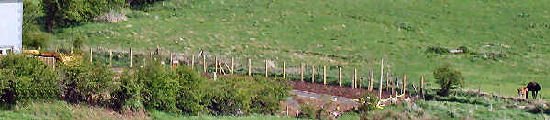 Wide photo of fence beside stream